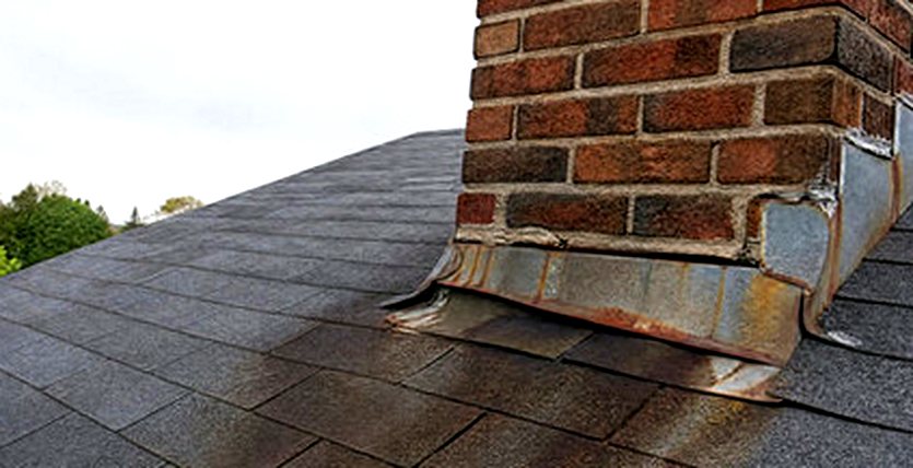 Rust streaking from failed chimney flashing across shingles
