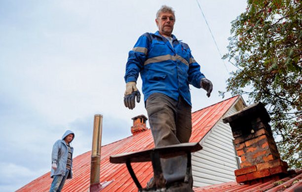 Two crewmen looking over a roof together